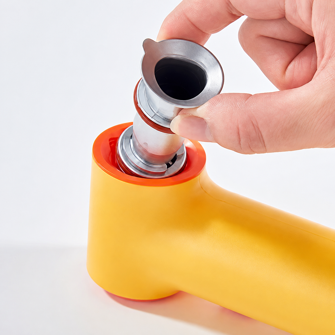 Hand lifting a silver-colored front fitting from the yellow airbrush tool