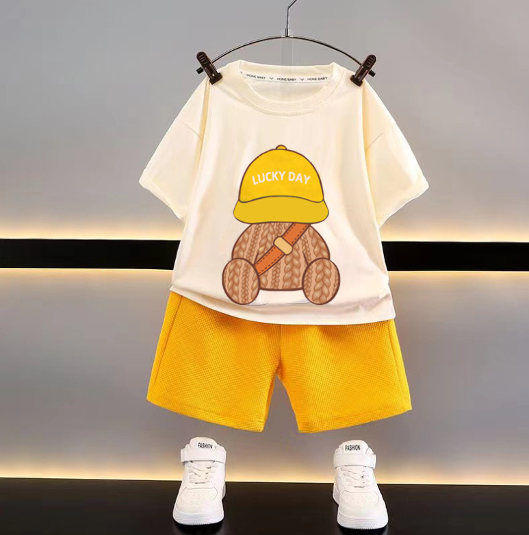 Cream T-shirt printed with a teddy bear in a yellow cap, paired with yellow shorts