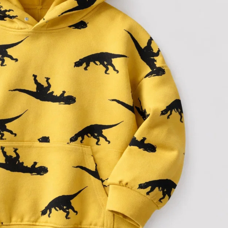 Close-up of the black dinosaur print and ribbed sleeve cuff on the yellow hoodie