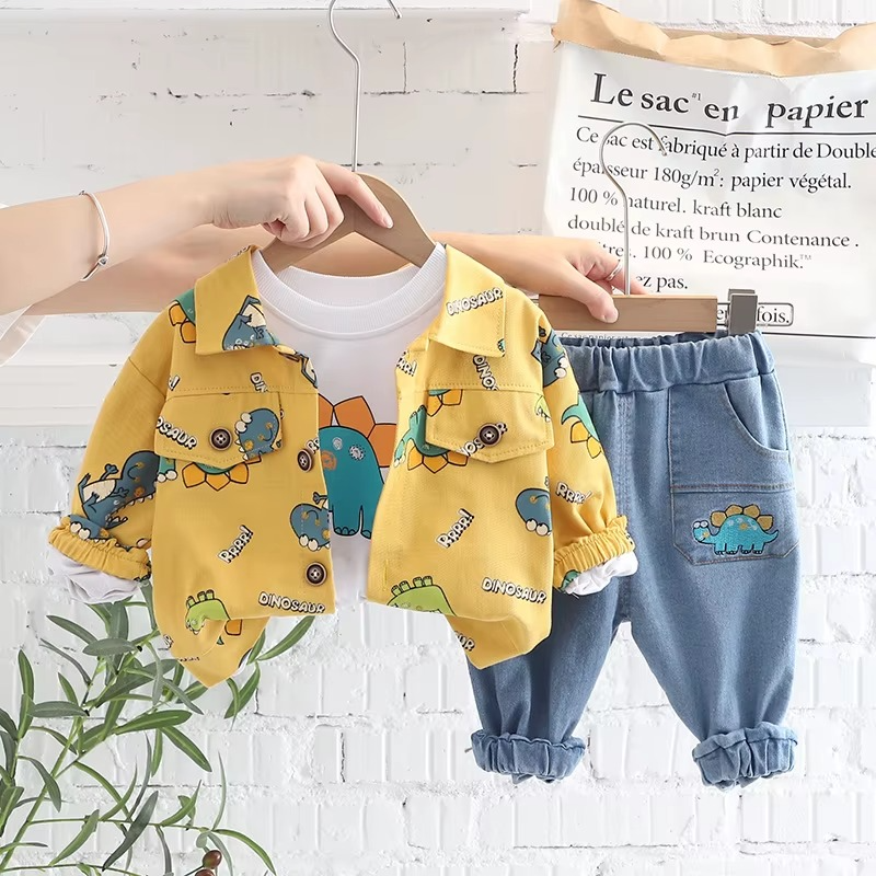 Yellow dinosaur-print jacket, white graphic T-shirt, and blue pants on wooden hangers