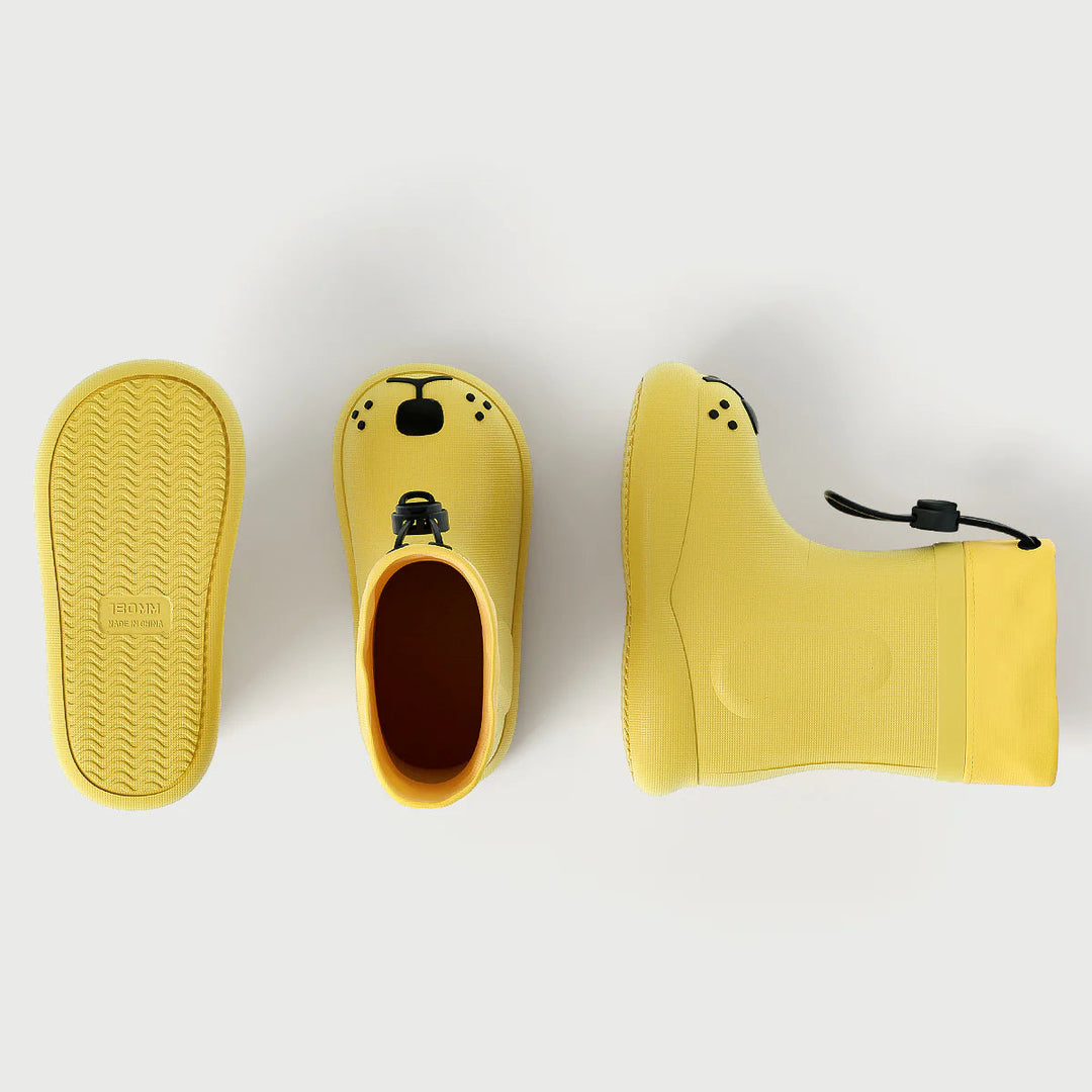 Yellow dog-face rain boots shown from the sole, top, and side to display tread and shape