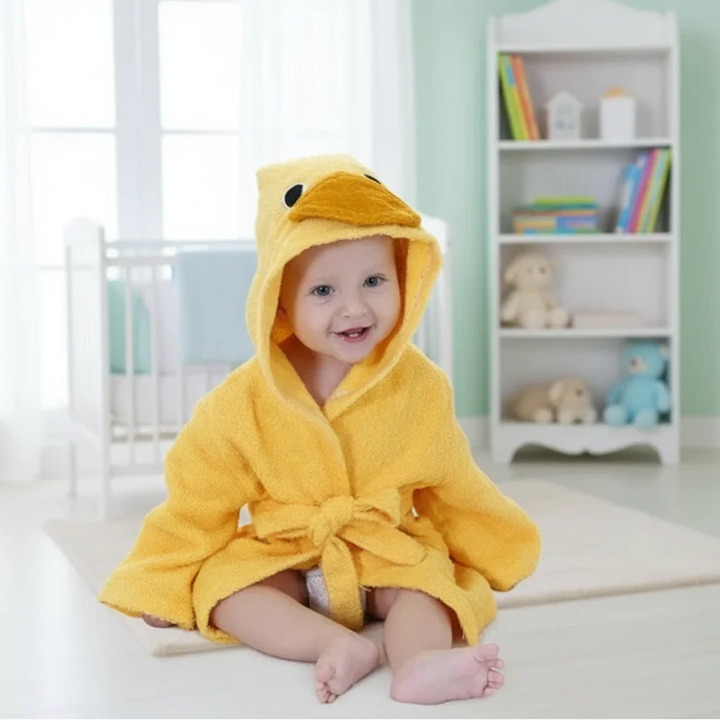Baby wearing a yellow duck bathrobe with a beak-shaped hood and a tied waist