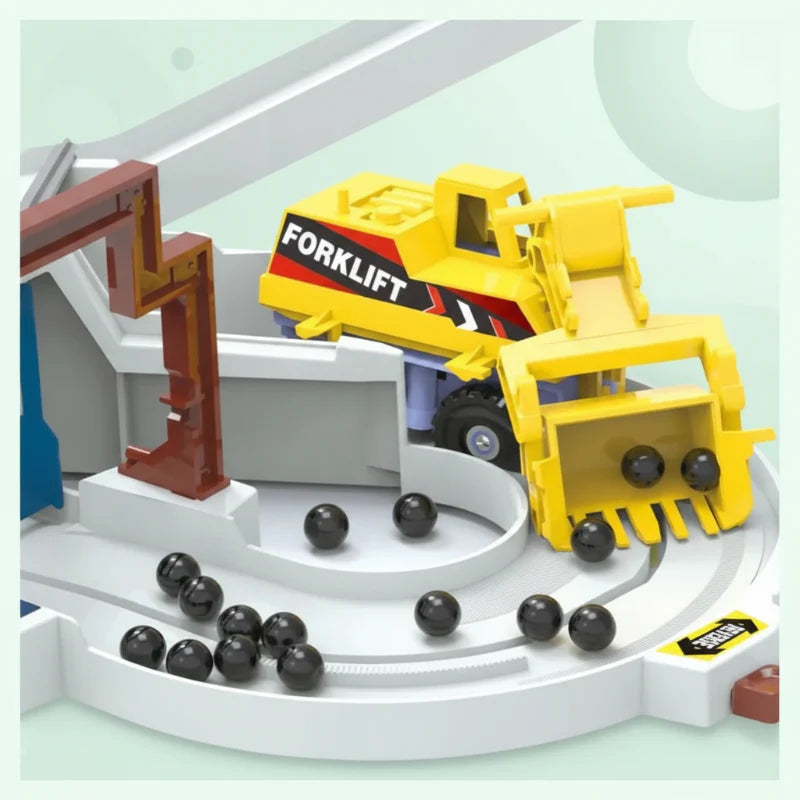 Yellow forklift attachment at a circular track section with black play balls