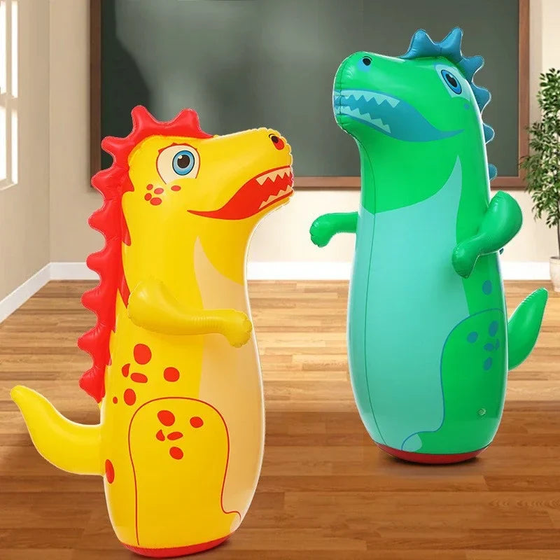 Yellow and green inflatable dinosaur punching bags standing indoors