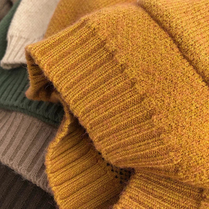 Close-up of a yellow sweater sleeve showing the knit texture and ribbed cuff