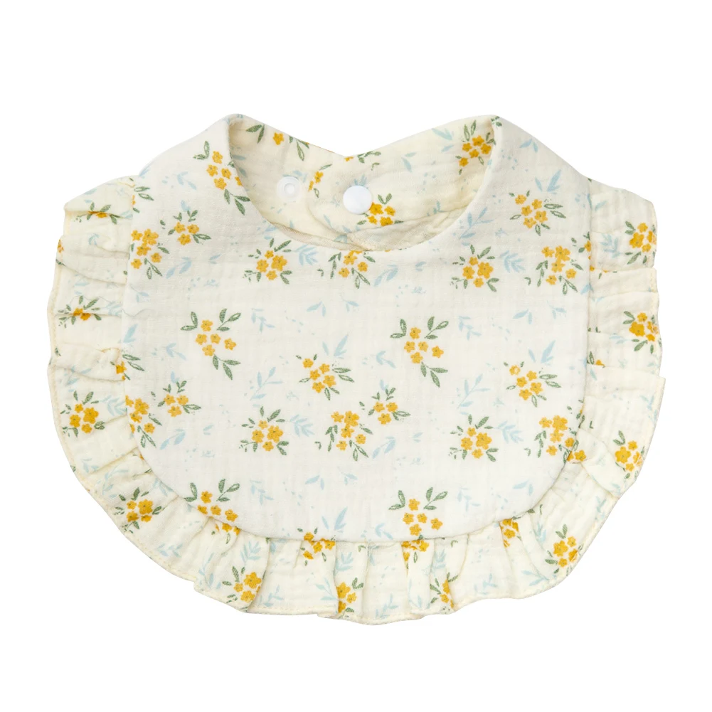 Light-colored cotton baby bib with yellow meadow flowers and a ruffled edge