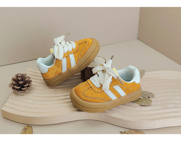 Yellow baby and toddler sneakers with white laces, white side stripes and rubber soles