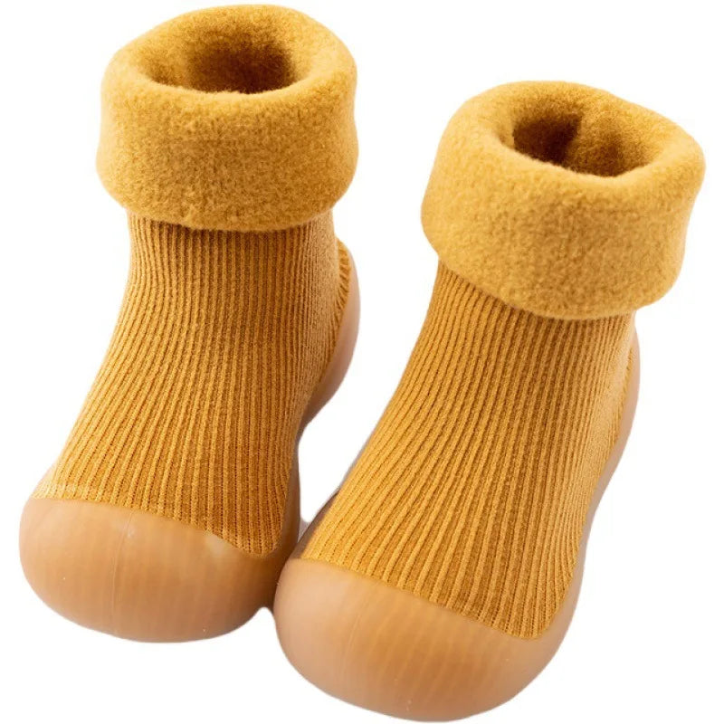 Yellow ribbed sock shoes with soft folded cuffs and rounded rubber toes.